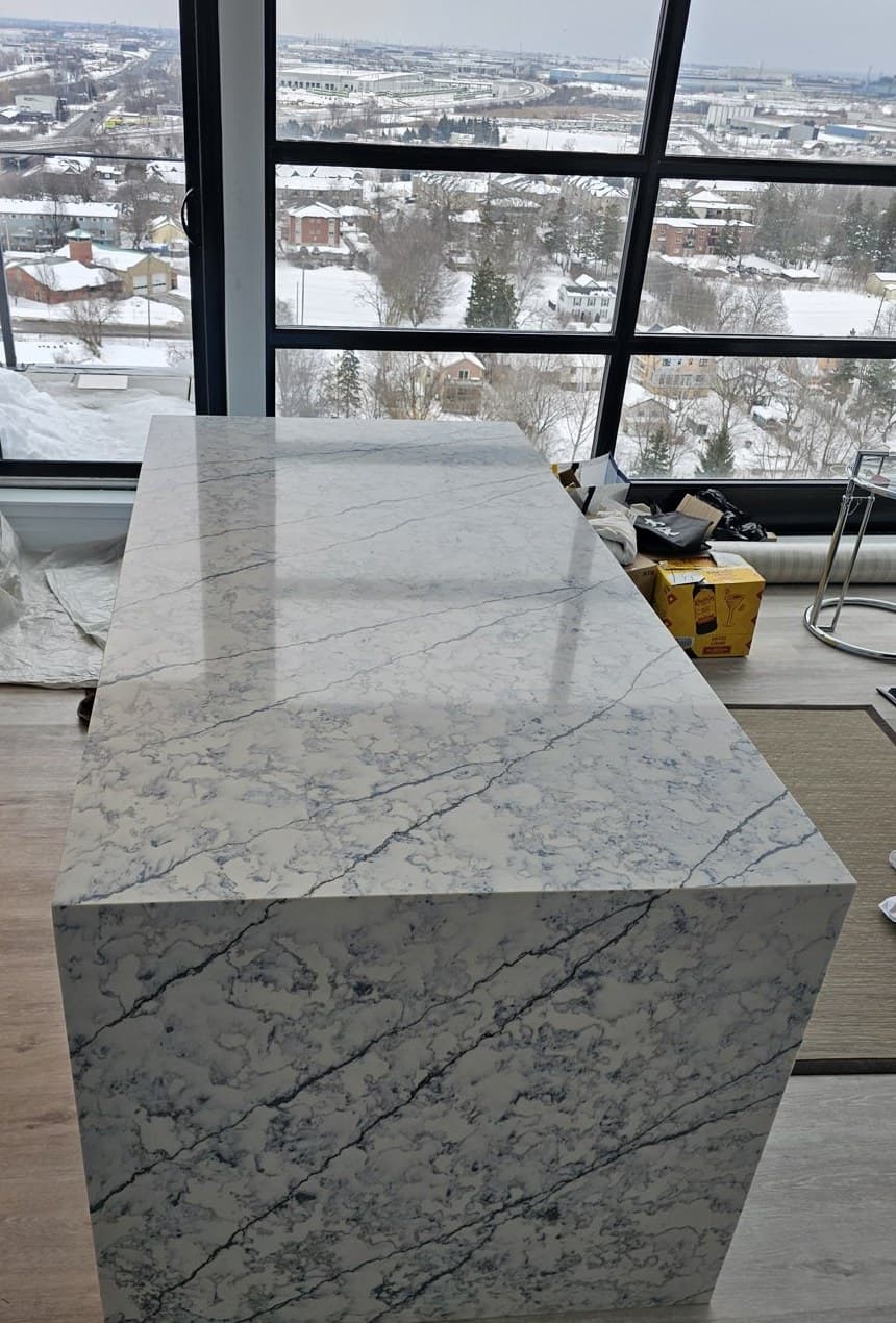 Lucent Quartz Blues Aria waterfall island in a Whitby condo kitchen with city view